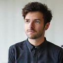 A confident and visionary portrait of a man with a thoughtful expression, symbolizing a co-founder.